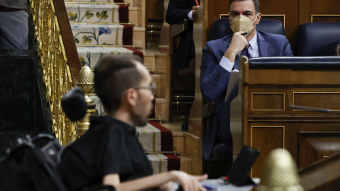 30/03/2022.- El presidente del Gobierno, Pedro Sánchez, escucha la intervención del líder de Podemos, Pablo Echenique (i), tras su comparecencia ante el pleno del Congreso para informar de las conclusiones del Consejo Europeo, la Cumbre de