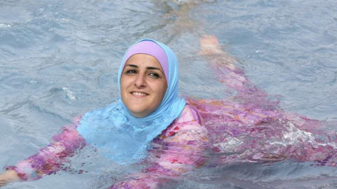 Una mujer turca se baña en una piscina en Berlín con un burkini. EFE/Archivo