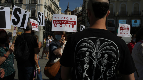 Un grupo de personas se reúne sosteniendo pancartas y carteles durante la concentración de la asociación Derecho a Morir Dignamente (DMD) en la Puerta del Sol, a 25 de junio de 2021, en Madrid, (España).