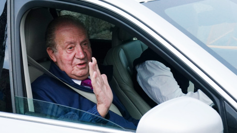 El rey emérito Juan Carlos I saluda desde un vehículo a su salida de la casa de Sanxenxo camino de Madrid, a 23 de mayo de 2022, en Sanxenxo.
