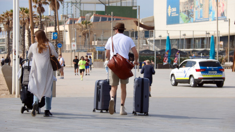 Dos turistes amb les maletes per la Barceloneta.