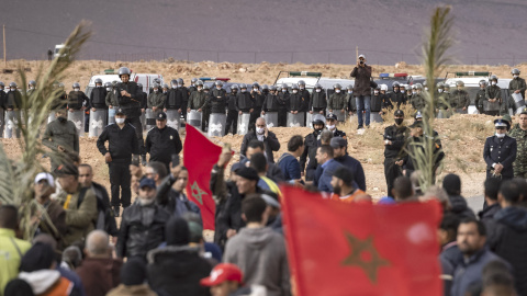 Las fuerzas de seguridad marroquíes montan guardia mientras los agricultores marroquíes protestan en la ciudad de Figuig el 18 de marzo de 2021, después de que las autoridades argelinas expulsaran a los cultivadores de dátiles del territori