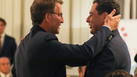 El presidente del Partido Popular, Alberto Núñez Feijóo (i) y el presidente de la Junta de Andalucía, Juanma Moreno (d), se saludan a su llegada al Foro Joly, en Madrid.