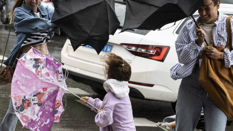18/8/22 Varias personas tratan de dominar sus paraguas en Donostia, a 18 de agosto de 2022.