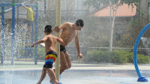 (14/7/2022) Dos jóvenes se refrescan en unos chorros durante un día de la segunda ola de calor de verano en España, a 14 de julio de 2022, en Ourense.