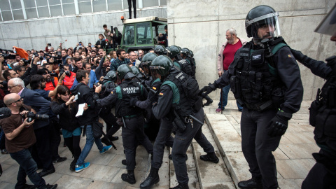 01/10/2017 - Agents de la Guàrdia Civil empenten votants a l'escola de Sant Julià de Ramis durant l'1-O de 2017.