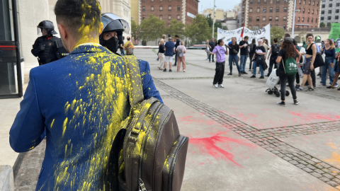 Un congressista tacat de pintura quan entrava a The District, amb manifestants al fons