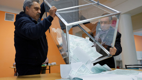 Miembros de la comisión electoral sacan las papeletas del referéndum de anexión de los territorios ucranianos a Rusia, en Donetsk (Ucrania) a 27 de septiembre de 2022.