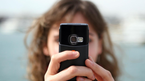 Una niña sostiene un teléfono móvil, en una imagen de archivo