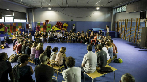 Famílies de l'escola i veïns del barri discuteixen en assemblea com mantenir oberta l'escola fins el matí de diumenge. XAVI HERRERO