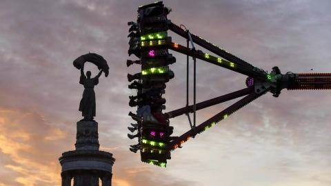 Varias personas montan en una atracción de feria, este lunes en Kiev (Ucrania). El Ejército ucraniano señaló este lunes que ha logrado interceptar y neutralizar gran parte de los drones y misiles que lanzó Rusia contra el país de forma masi