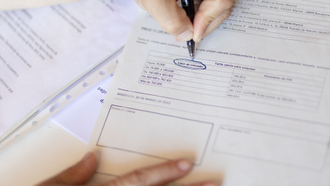 Una mujer señala el valor de mercado de una escritura de compraventa de una hipoteca, a 30 de mayo de 2022, en Madrid (España).