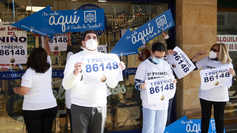 Empleados de la administración situada en la calle Cervantes de Santoña celebran que han vendido parte del número 86148 correspondiente al 'Gordo' del Sorteo Extraordinario de la Lotería de Navidad, a 22 de diciembre de 2021
