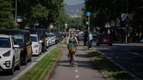 Una mujer circula montada en bicicleta en un carril bici de Barcelona en mayo de 2022.