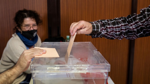 Imagen de archivo de una persona introduciendo su voto en una urna, a 23 de octubre de 2021, en Madrid.