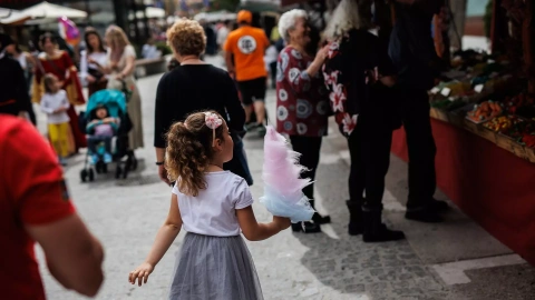 Una niña con un algodón de azúcar en el mercadillo, de la Feria Medieval de El Álamo, a 30 de abril de 2022