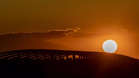 El sol se oculta por el puente del Tercer Milenio de Zaragoza, en mitad de la ola de calor del mes de abril.