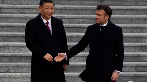 El presidente francés, Emmanuel Macron, estrecha su mano con el mandatario chino Xi Jinping durante la ceremonia de bienvenida en el Gran Palacio del Pueblo en Pekín, a 6 de abril de 2023