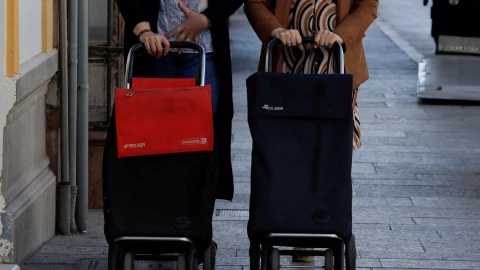 Dos mujeres llevan sus carros de la compra en la localidad malagueña de Ronda. REUTERS/Jon Nazca