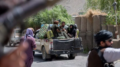 En esta fotografía tomada el 8 de julio de 2022, los combatientes talibanes pasan por un puesto de control de carretera cerca en la provincia de Panjshir, en Afganistán.