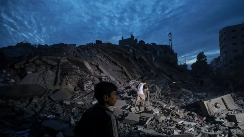 Menores inspeccionan los alrededores destruidos de la Torre Palestina después de que aviones de combate israelíes la atacaran en la ciudad de Gaza, el 7 de octubre de 2023.