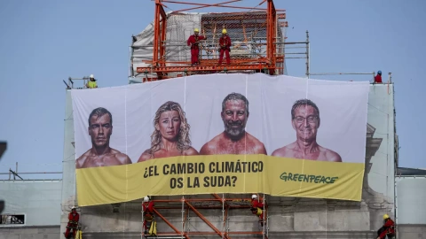 Activistas de Greenpeace han desplegado una lona en la emblemática Puerta de Alcalá de Madrid en la que preguntan a los principales candidatos a la presidencia del Gobierno si el cambio climático "se la suda".