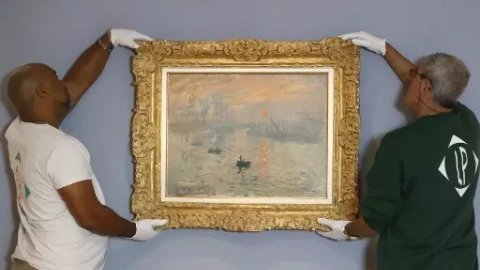 Empleados del Musee Marmottan Monet sostienen la pintura "Impression, Sunrise" ("Impression soleil levant") del pintor francés Claude Monet.