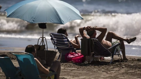 Numerosas personas disfrutan del buen tiempo y sol el domingo en la playa del Rincón de la Victoria (Málaga).