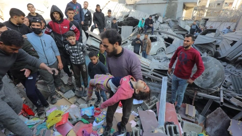 Una niña es sacada de los escombros de un edificio tras un bombardeo israelí en el campo de refugiados de Nuseirat, en la Franja de Gaza, a 30 de diciembre de 2023.