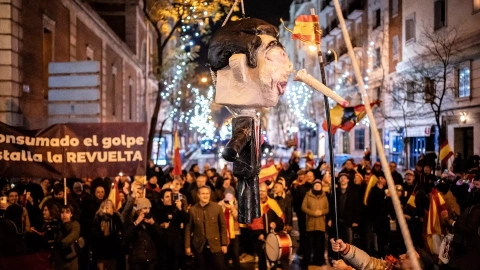 Decenas de personas celebran la entrada del año nuevo en la calle Ferraz golpeando un muñeco de Pedro Sánchez, a 1 de enero de 2024, en Madrid.