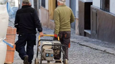 Dos trabajadores trasladan un generador a una obra en una casa en la localidad malagueña de Ronda. REUTERS/Jon Nazca