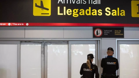 Dos agentes de la Policía Nacional en la puerta de llegadas de la terminal T1 del Aeropuerto Adolfo Suárez Madrid Barajas ante la llegada del expresidente de la Real Federación Española de Fútbol (RFEF), a 3 de abril de 2024.
