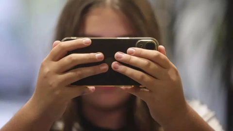 Una joven consulta su teléfono móvil en una imagen de archivo.