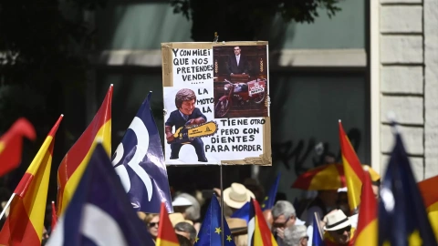 Una persona sujeta un cartel de protesta durante una manifestación del PP, en la Puerta de Alcalá, a 26 de mayo de 2024, en Madrid.