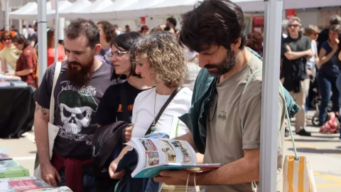 Diverses persones mirant llibres en una de les parades de la Fira Literal a Barcelona