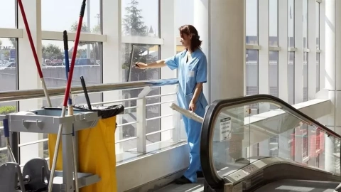 Una treballadora de neteja en un edifici d'oficines.