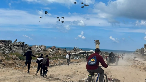 26/3/24- Los palestinos se apresuran hacia la playa para recoger la ayuda lanzada desde un avión, en medio del actual conflicto entre Israel y Hamás, en el norte de la Franja de Gaza, a 25 de marzo de 2024.