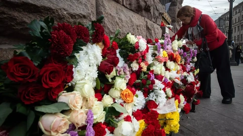 Mujer rusa lleva una flor para conmemorar a las víctimas mortales del atentado terrorista en el auditorio Crocus City Hall, en Moscú, a 24 de marzo de 2024.