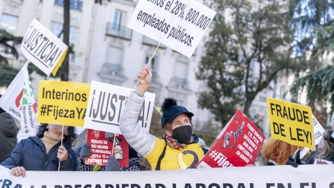 Un grupo de personas con carteles durante una manifestación de interinos frente al Congreso de los Diputados.