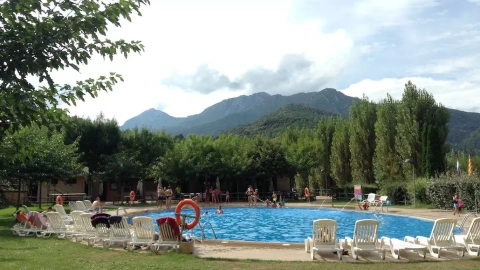 La piscina d'un càmping amb diversos clients banyant-s'hi.