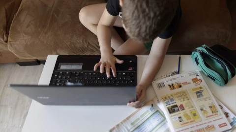 Un alumno de primaria hace los deberes con un ordenador. Imagen de archivo.
