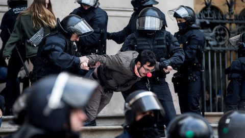 Agentes de los Mossos en el momento en el que desalojan a los manifestantes ante el TSJC. EFE/Quique García