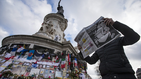 Un hombre ojea el número especial publicado por el semanario satírico 'Charlie Hebdo' con motivo del primer aniversario del atentado yihadista contra su redacción, en la Plaza de la República de París. EFE/Ian Langsdon