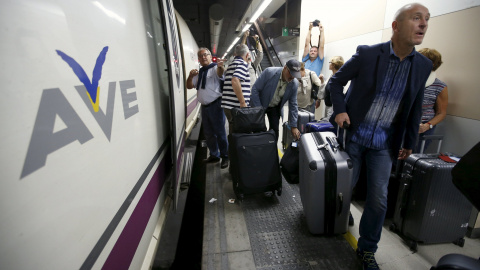 Pasajeros con sus maletas andando por un andén de la estación de Sans de Barcelona tras tener que bajarse de un tren AVE. /REUTERS
