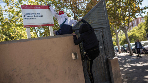 Dos menores migrantes saltan el muro para acceder al Centro de Primera Acogida de Menores de Hortaleza, en Madrid.- JAIRO VARGAS