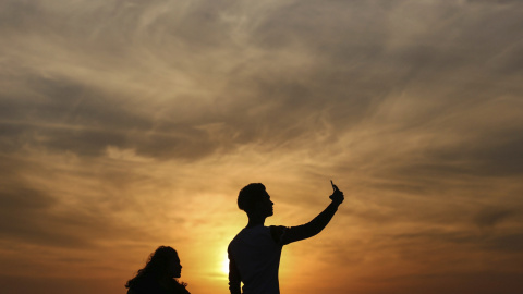 Varias personas se hacen un selfie en el paseo marítimo de Bandra Fort Band Stand junto al mar arábigo en Bombay, India. EFE/Divyakant Solanki