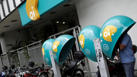 Un hombre habla por un teléfono público con el logotipo de la compañía brasileña de telecomunicaciones Oi frente a la oficina de la compañía en Río de Janeiro. REUTERS / Ricardo Moraes