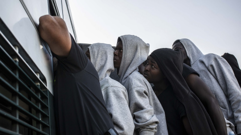 Varios migrantes suben a un autobús de la Guardia Civil para ser trasladados desde el puerto de Algeciras, en agosto de 2018.- JAIRO VARGAS (ARCHIVO)
