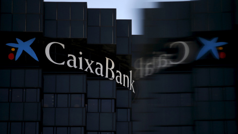 El logo de CaixaBank se refleja en un cristal, en la sede de la entidad en Barcelona. REUTERS/Albert Gea