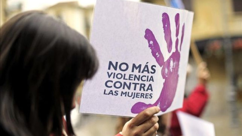 Una mujer porta una pancarta en contra de la violencia machista | EFE